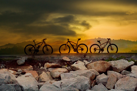 Silhouette of mountain biker in sunset on the meadow