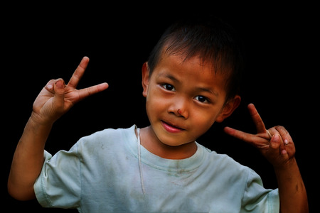 Portrait of beautiful little boy giving you thumbs up over white backgroundの写真素材