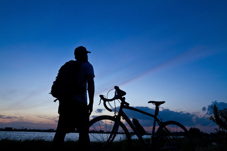 man stand on Mountain bike silhouette in sunriseの写真素材