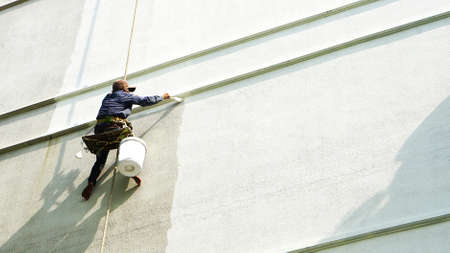 painter hanging on white buildingの写真素材