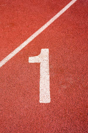 number one in red  running track on the athletic stadiumの写真素材