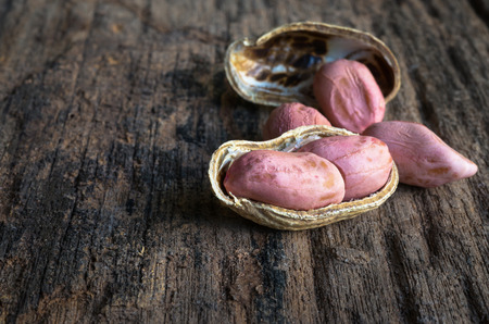 peanuts in shells on wood background