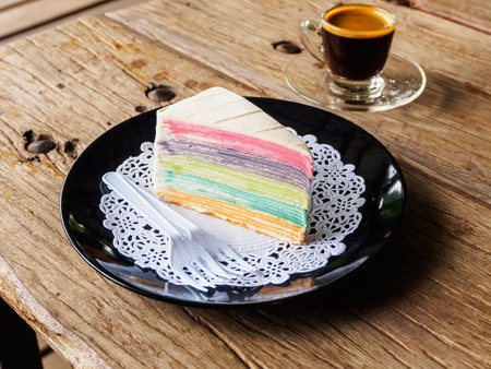 Rainbow crape cake on black plate. (Selective Focus)