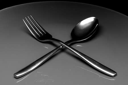 silver fork and spoon as utensils on plateの写真素材