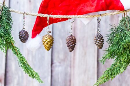 Pine cones hanging on a rope with wooden background.の写真素材