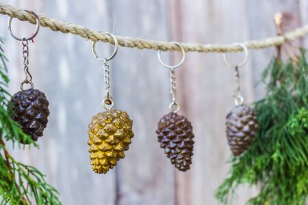 Pine cones hanging on a rope with wooden background.の写真素材