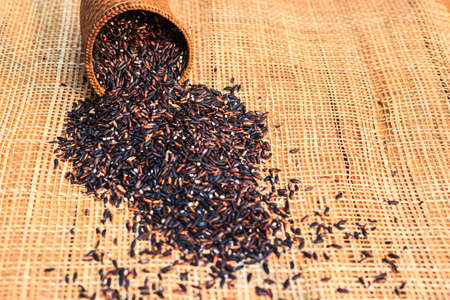 black rice in basket on bamboo mat.の写真素材