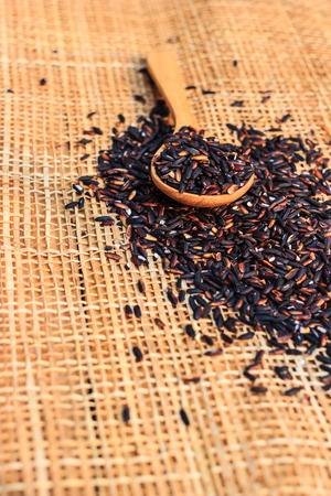 black rice in a wooden spoon.の写真素材