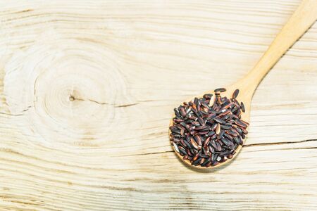 rice on wooden spoon on white wood background. Product of Thailand, Asia.の写真素材