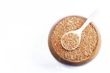 Sangyod brown GI rice on wooden spoon isolated on white background. Product of Thailand, Asia.の写真素材