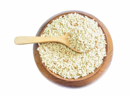 Brown rice on wooden spoon isolated on white background. Product of Thailand, Asia.の写真素材