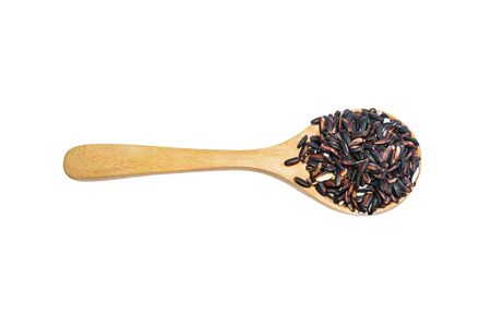Black rice on wooden spoon isolated on white  background. Product of Thailand, Asia.の写真素材