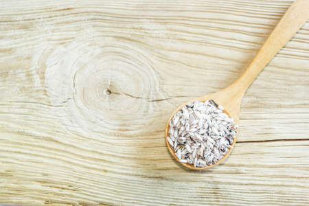 Rice on wooden spoon on woodden  background. Product of Thailand, Asia.の写真素材