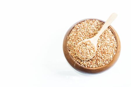 Red rice on wooden spoon in a wooden bowl isolated on white  background. Product of Thailand, Asia.の写真素材