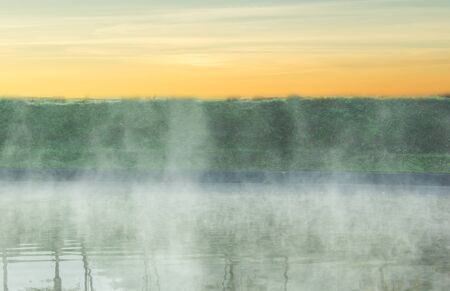 Sky gradient from blue to orange sunset with morning mistの写真素材