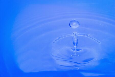 Water drop falling into water making a perfect droplet splashの写真素材