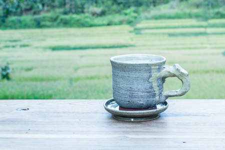 Cup with tea on table over mountains landscape with sunlight. Beauty nature background.の写真素材