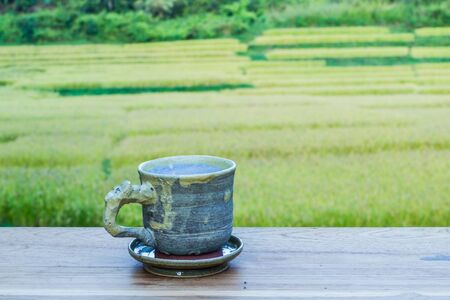 Cup with tea on table over mountains landscape with sunlight. Beauty nature background.の写真素材