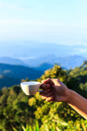 Cup of coffee in morning over mountain.の写真素材