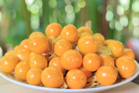 Orange Organic Cape Gooseberries in a plate on woodenの写真素材