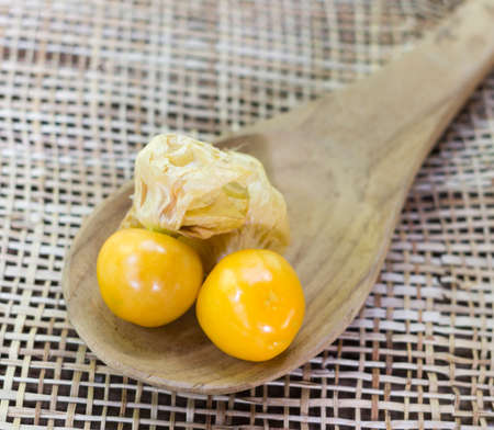 Orange Organic Cape Gooseberries in a wooden spoonの写真素材