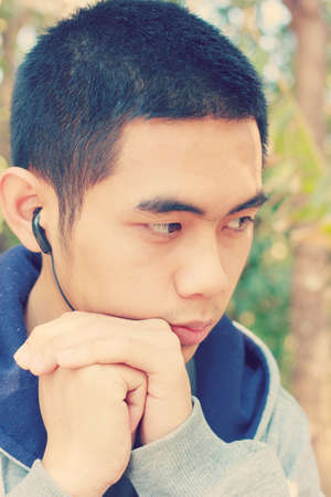 Portrait of Asia young teenage boy. Hand on chin.Vintage style.の写真素材