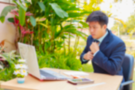 blurred office background , Satisfied businessman working on laptop with internet wirelessの写真素材