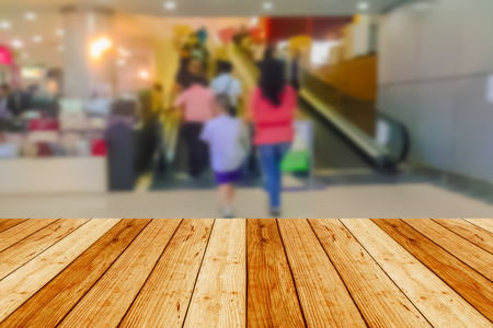 blurred image wood table and abstract department store shopping mall center and people backgroundの写真素材