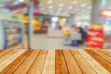 blurred image wood table and abstract department store shopping mall center and people backgroundの写真素材
