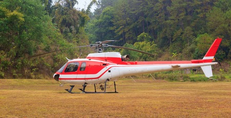 Red helicopter at heliport in mountainの写真素材
