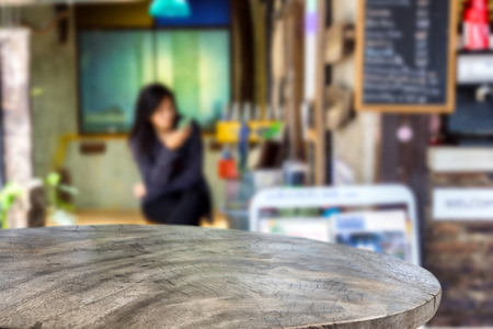 Empty wooden table and Coffee shop interior with some people blur background with bokeh image, for product display montage,can be used for montage or display your productsの写真素材