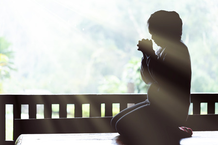 Young girl praying with holy bible in the morning. Woman praying to god. Christianity concept. Pray concept. Faith hope love concept.の写真素材