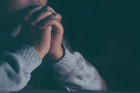 Young teen girl praying with hands close up, vintage effect,soft focus.の写真素材