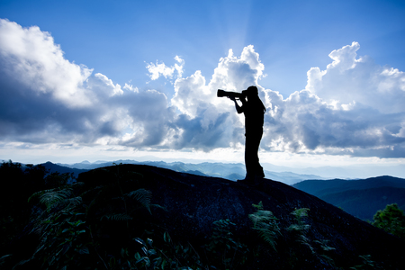 Silhouette of a man who like to travel and photographer, taking pictures of the beautiful moments during the sunset ,sunrise.の写真素材