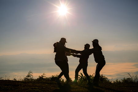 Silhouettes of peoples take photos on top of mountain with sunriseの写真素材