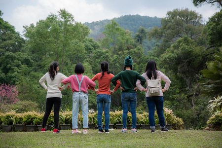 Group of friends standing together on greensward and enjoying themselves. Young women enjoying on their holiday outdoors.の写真素材
