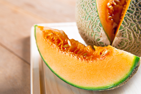 Fresh sweet orange melon on the wooden tableの写真素材