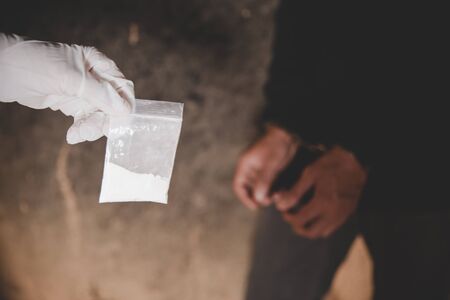 illegal transport of drugs. A police officer finds drugs during the search of drug dealers. Law and police concept.の写真素材
