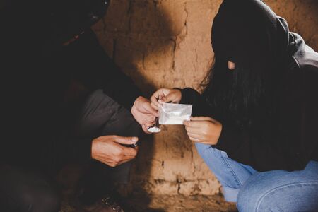 close up of young people smoking cigarettes and using drugs outdoors,  substance abuse, addiction and bad habits conceptの写真素材