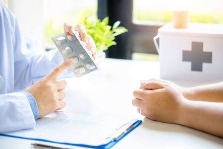 Male doctor and patient on light background. He Doctors explain the use of medication, Medicine and...