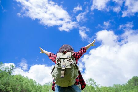 Travelers, young women, look at the amazing mountains and forests, wanderlust travel ideas, space for messages, great moments of the atmosphere.の写真素材