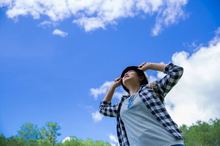 Travelers, young women, look at the amazing mountains and forests, wanderlust travel ideas, space for messages, great moments of the atmosphere.の写真素材