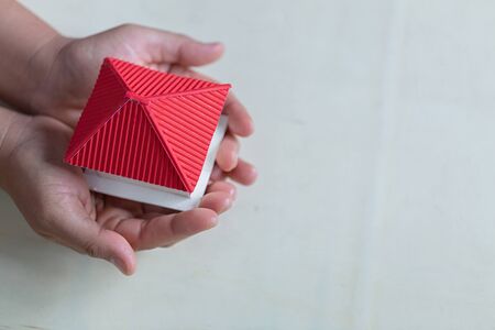 Human hands holding model of dream house, loans and investments conceptの写真素材