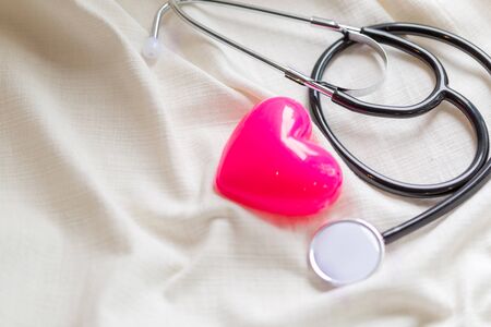 Health care life insurance concept, Simply minimal design with medicine equipment stethoscope or phonendoscope and red heart isolated on trendy pastel blue background. Instrument device for doctor.の写真素材