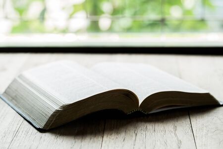Holy Bible on a wooden table with morning sun for devotion to Christiansの写真素材