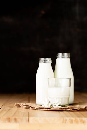 Fresh milk two bottle glass on the wooden table Black backgroundの写真素材