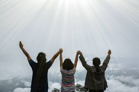 Christian worship with raised hand in forest, Happy teens deep breath fresh air on top mountain...