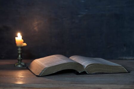 Scriptures and candles on a wooden table, golden background, beautiful, religious conceptsの写真素材
