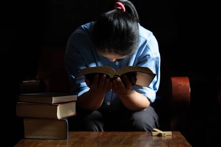 Family group are praying together on wooden table with the light from candle with copy space for your text
の写真素材