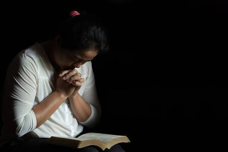 Spirituality and religion, Hands folded in prayer on a Holy Bible in church concept for faith.